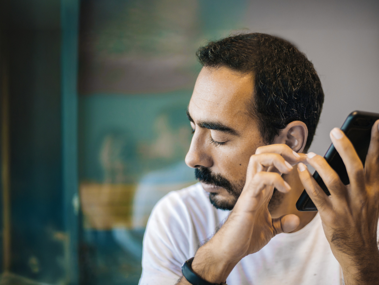 A man operating his cellphone through audio cues