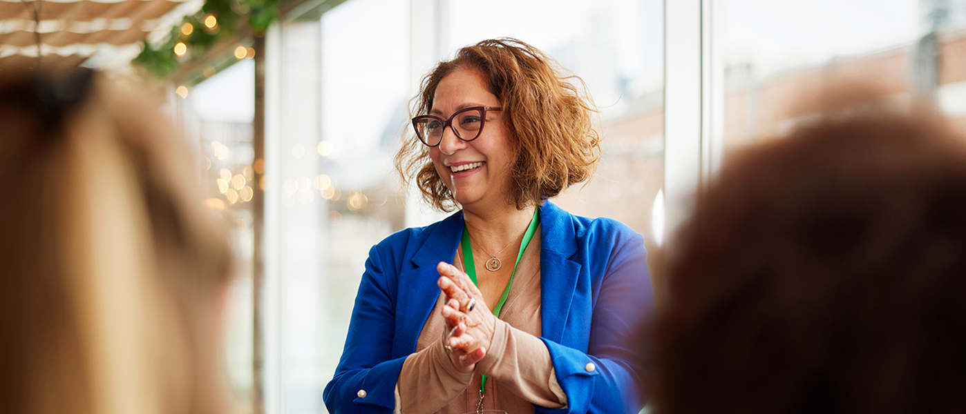 A woman smiling and giving a presentation