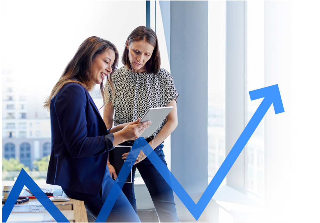 Photo of two women in an office looking at a tablet
