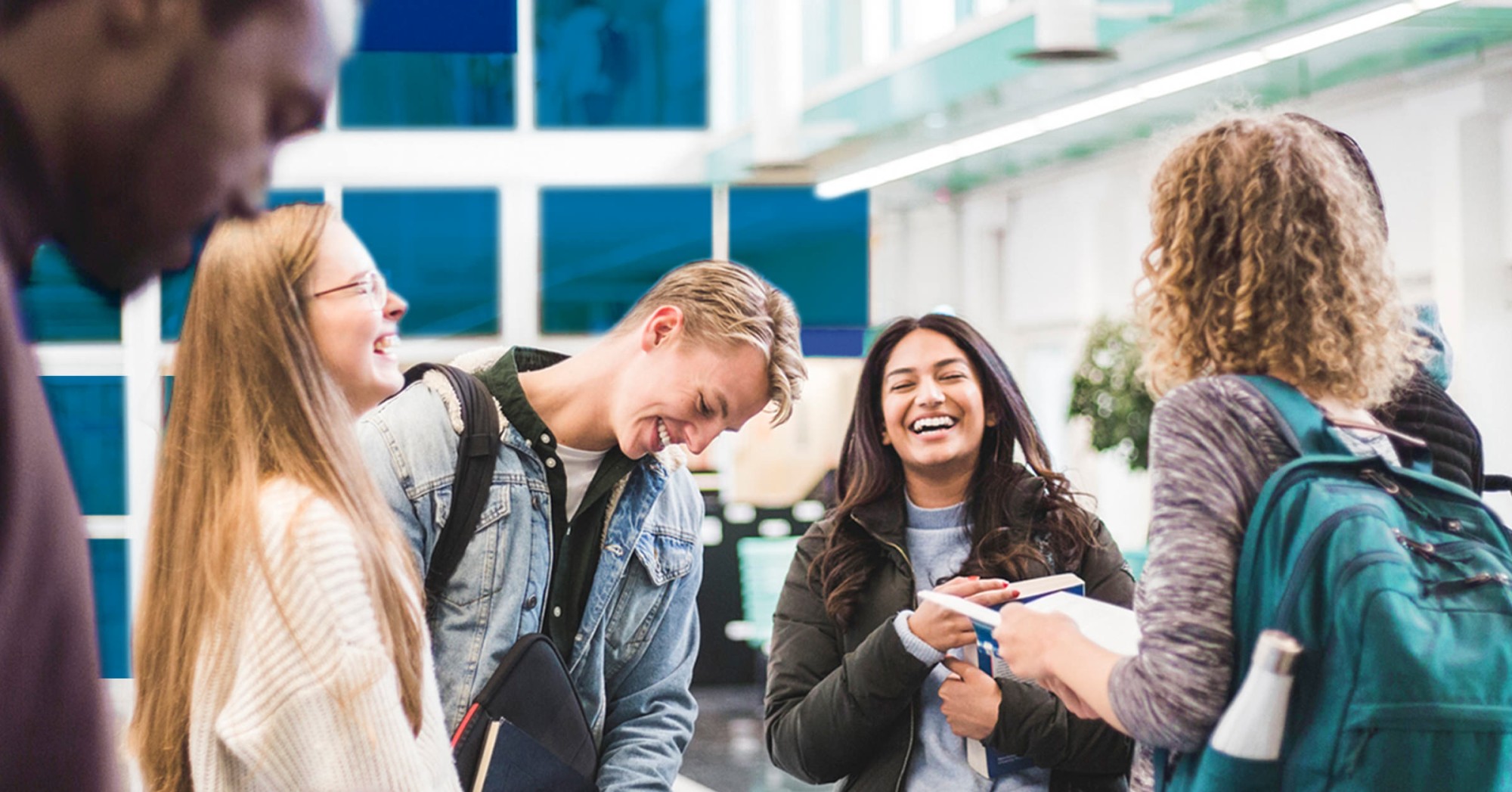 Image of a group of students smiling while they are sharing as friends