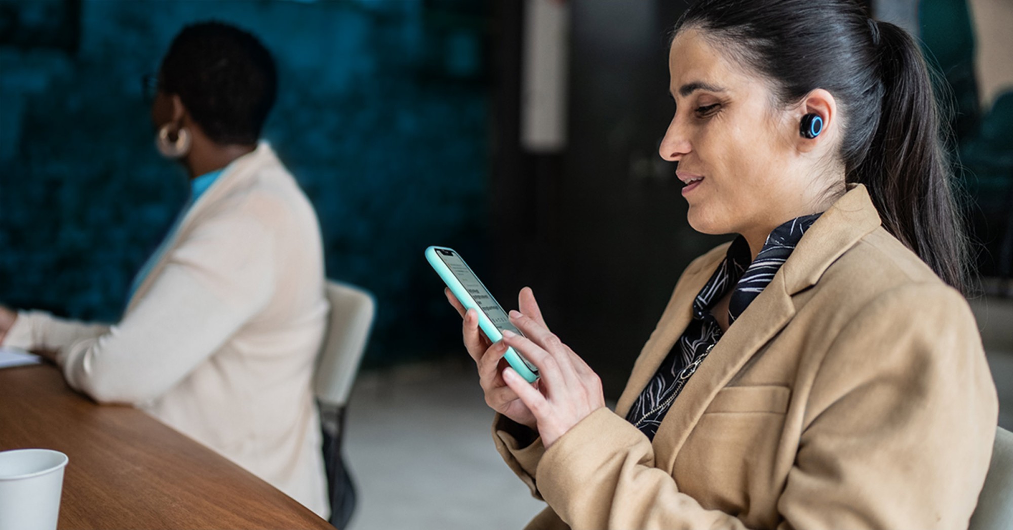 Photo of a woman using an assistive device with her phone