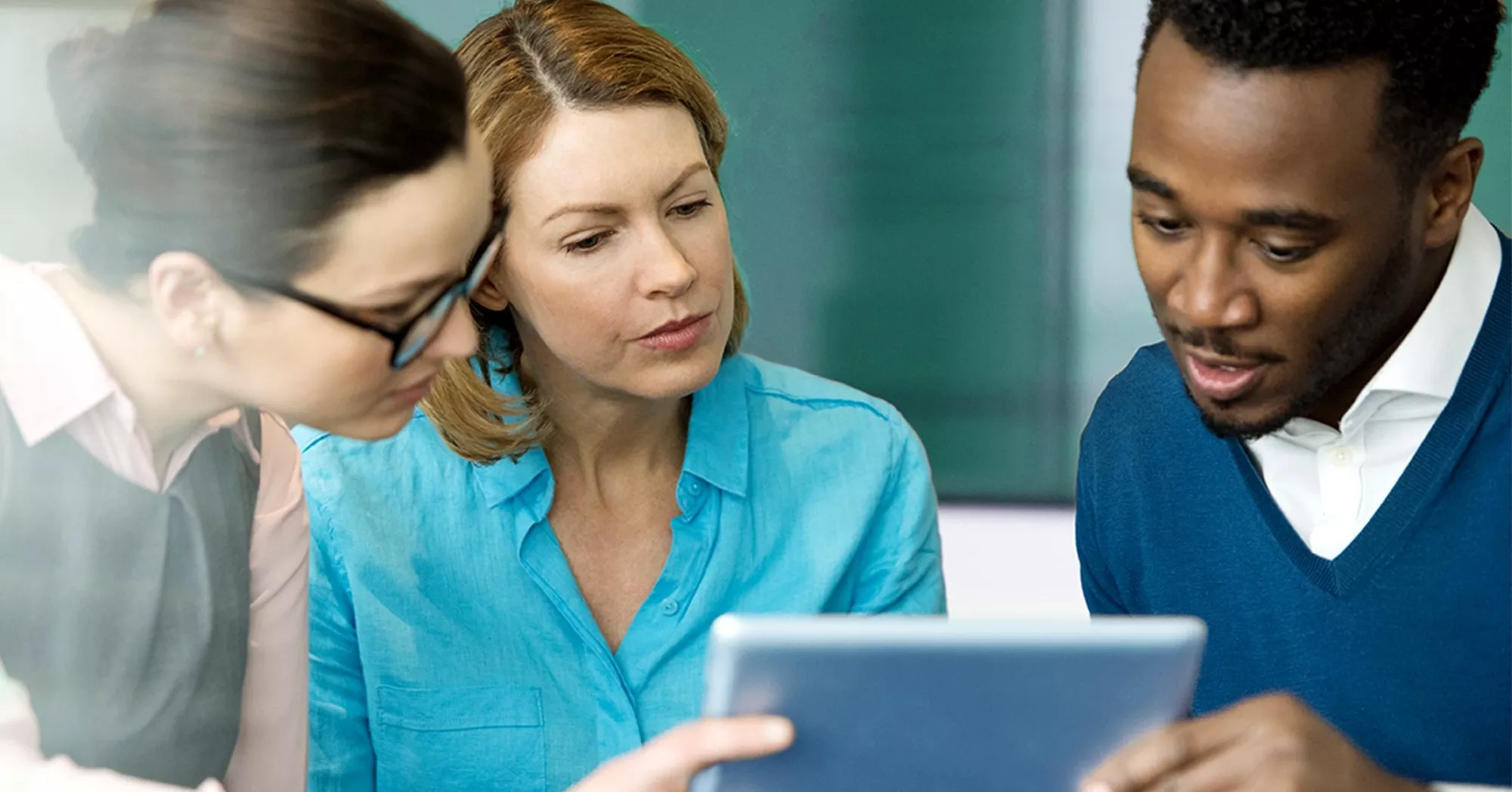 Imagen de tres personas trabajando con un computador