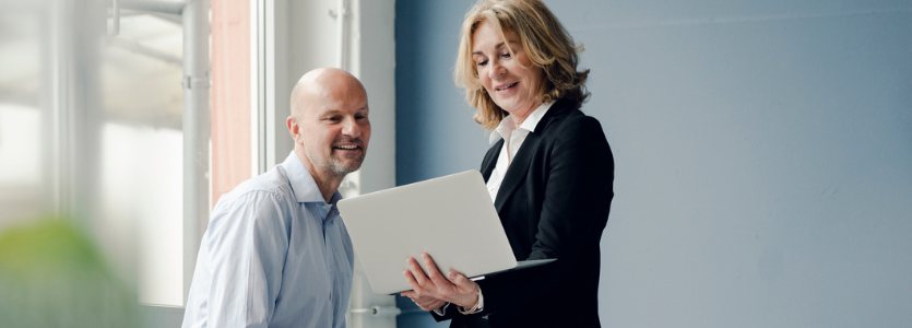 Photo of two people looking at something on a laptop