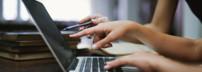 Close up photo of hands working at a laptop