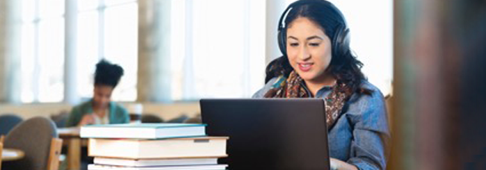 Woman listening to and watching webinar on laptop.